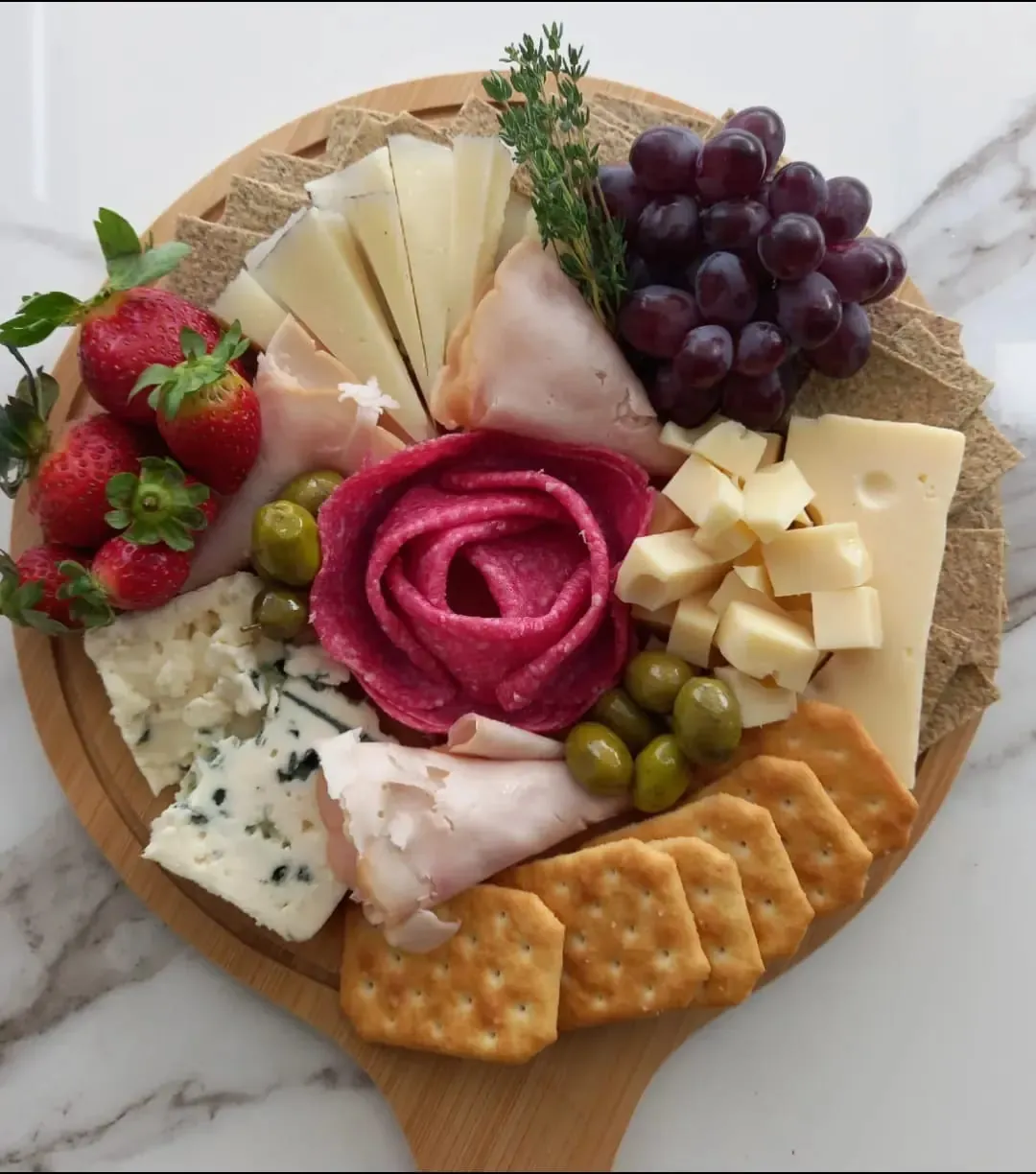 Board with a salami rose and strawberries